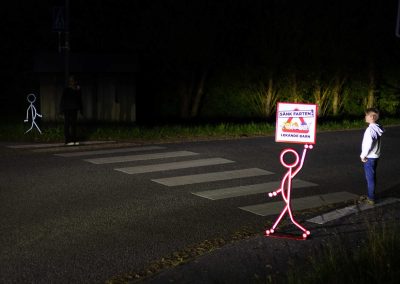Barn väntar i mörker vi "Lekande Barn"-skylt från Reflexis